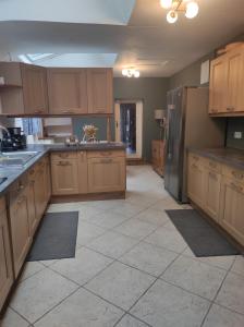 a large kitchen with wooden cabinets and stainless steel appliances at Rose Cottage in Huelgoat