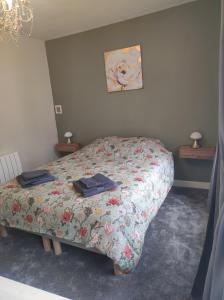 1 dormitorio con 1 cama con edredón de flores en Rose Cottage, en Huelgoat