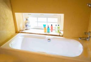 a bath tub in a bathroom with a window at Bohemian Experience Wellness, Jacuzzi, Sauna, BBQ, Garden, Sleeps 14 in Kockengen