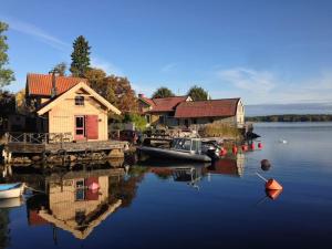 eine Anlegestelle mit einem Haus und Booten im Wasser in der Unterkunft Hus med ateljé i Centrala Vaxholm in Vaxholm