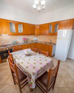 a kitchen with a table and a white refrigerator at Vila Feimi in Ksamil
