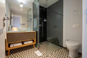 a bathroom with a sink and a toilet at Santa Catarina FLH Suites in Porto