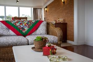 een woonkamer met een bank en een tafel bij Locar-in Gramado- Jardim Europa in Gramado