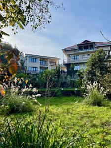 ein großes Haus in einem Hof mit Rasen in der Unterkunft SV Hotel Batumi in Makhinjauri