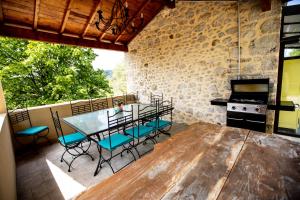 a kitchen with a table and chairs and a stove at GÎTES DU MAS BEL'AIR ,PISCINE CHAUFFÉE in Rosières