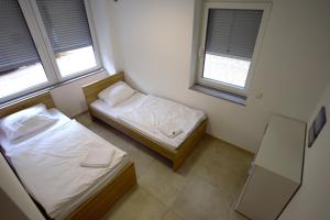 twee bedden in een kleine kamer met twee ramen bij Apartment in Stuttgart Bad Cannstatt/Nähe Stadtion in Stuttgart