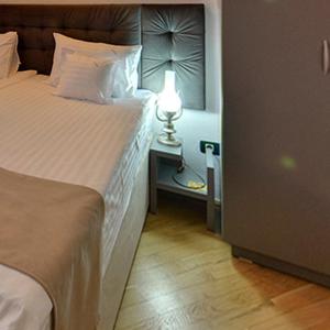a bedroom with a bed with a lamp on a table at Ambra Boutique Hotel & Bistro in Constanţa