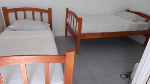 duas camas num quarto com duas cadeiras em CasaLeon em Mejillones
