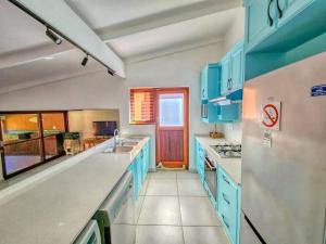 a kitchen with blue cabinets and a counter top at San Lameer 2401 by Top Destinations Rentals in Southbroom
