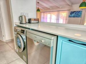 a kitchen with a washer and dryer under a counter at San Lameer 2401 by Top Destinations Rentals in Southbroom +31 photos