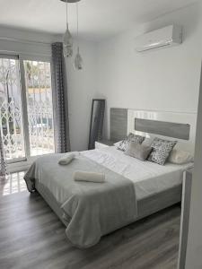 a white bedroom with a large bed and a window at Casa Beavan in Alicante +37 photos