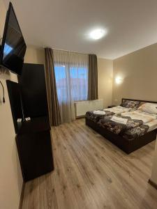 a bedroom with a bed and a flat screen tv at Rila Hills in Samokov