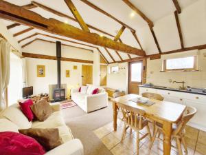 a living room with a table and a kitchen at The Dairy , Petersfield in Petersfield