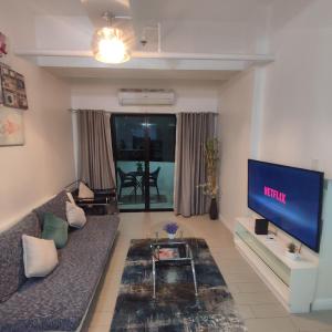 uma sala de estar com um sofá e uma televisão de ecrã plano em Luxury spacious 2BR in Salcedo Village em Manila