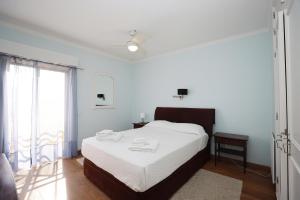 una camera bianca con un letto e una finestra di C27 - Torraltinha Way Apartment a Lagos