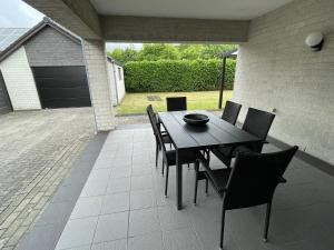 una mesa negra y sillas en un patio en Vakantiewoning Villa 35 en Maasmechelen