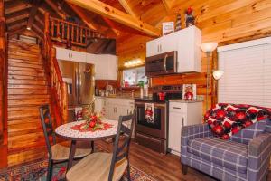eine Küche mit einem Tisch und einem Sofa in einer Hütte in der Unterkunft Charming Lakeview Cabin Near Geneva-On-The-Lake! in Ashtabula