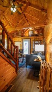 Charming Lakeview Cabin Near Geneva-On-The-Lake! في أشتابولا: غرفة معيشة من كابينة خشب مع أريكة