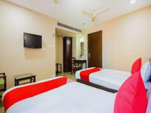um quarto de hotel com duas camas e uma televisão de ecrã plano em Hotel Famy Palace em Udalguri