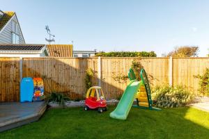 a backyard with a playground with a slide at 4BR Beach House sleeps 10 - 5 mins walk to the Sea in West Wittering