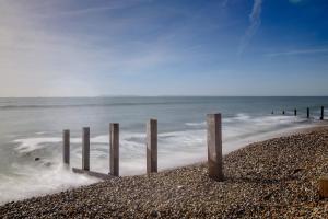 a group of wooden posts on the beach at 4BR Beach House sleeps 10 - 5 mins walk to the Sea in West Wittering