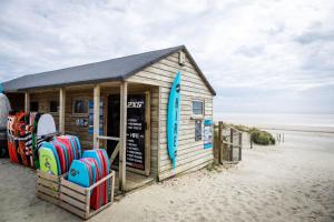 a building on the beach with surfboards at 4BR Beach House sleeps 10 - 5 mins walk to the Sea in West Wittering