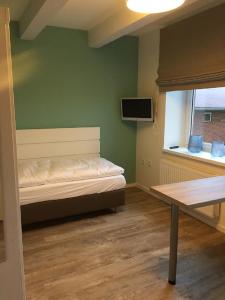 Zimmer mit einem Bett, einem Tisch und einem Fenster in der Unterkunft Ferienhof Pankalla in Neubruchhausen