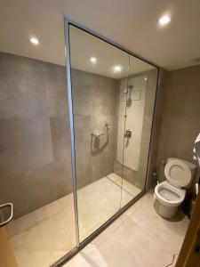 y baño con ducha de cristal y aseo. en Paiva Home Stay - Bugan Paiva by Flatbpaiva, en Recife