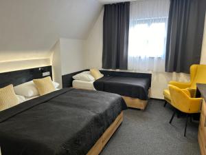 Cette chambre comprend 2 lits et une fenêtre. dans l'établissement Hotel 14Dveří, à Drnholec