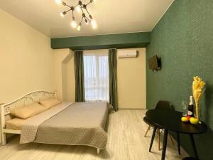 a bedroom with a bed and a table and a window at Parkoviy kvartal in Kharkiv