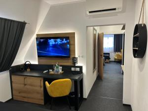 a room with a desk and a television on a wall at Hotel 14Dveří in Drnholec