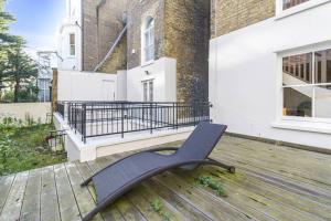 a bench sitting on the deck of a house at Notting Hill 2BR Gem l Stylish Prime Apt in London