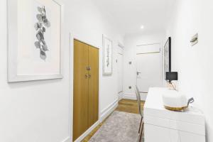 a white room with a desk and a wooden door at Notting Hill 2BR Gem l Stylish Prime Apt in London