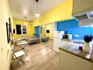 a kitchen and living room with yellow and blue walls at Parkoviy kvartal in Kharkiv