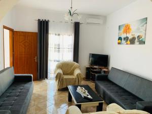a living room with two couches and a tv at Vila Feimi in Ksamil