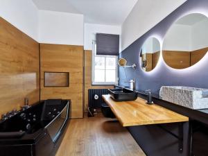 a bathroom with a black tub and a sink at BohnApartments Steigerwald - Natur in der Stadt - Vollausstattung - WLAN - Parkplätze in Erfurt