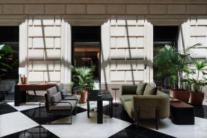 a lobby with chairs and tables and plants at Hotel Casa Lucia in Buenos Aires