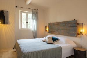 sypialnia z łóżkiem, 2 lampami i oknem w obiekcie Le Mas Paradou, 5 chambres, piscine privée, accès au village à pied w mieście Paradou +11 zdjęć