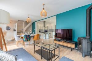 a living room with a tv and a living room with a stove at Wasquehal - maison 3 chambres in Wasquehal