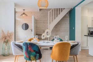 a dining room with a table with chairs and a staircase at Wasquehal - maison 3 chambres in Wasquehal