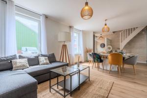 a living room with a couch and a table at Wasquehal - maison 3 chambres in Wasquehal