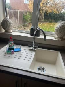 ein Waschbecken in einer Küche mit Fenster in der Unterkunft Bonningtons - Charming 2 Bed Property In Brentwood in Shenfield