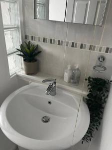 ein Badezimmer mit einem weißen Waschbecken und einem Spiegel in der Unterkunft Bonningtons - Charming 2 Bed Property In Brentwood in Shenfield