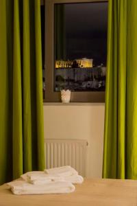 a room with a table with a window with green curtains at Superb Acropolis View From A Central Brand New Apt in Athens
