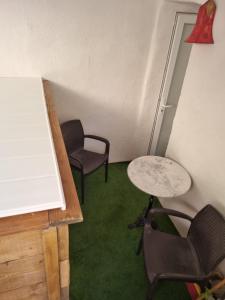 2 Stühle und ein Tisch in einem Zimmer mit grünem Teppich in der Unterkunft Casa Luna in Lunas