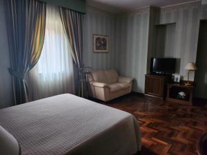 a bedroom with a bed and a chair and a television at Dimora della via Appia PRETORIA in Potenza