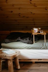 a bed in a wooden room with a table at Głuszecki las in Skórcz