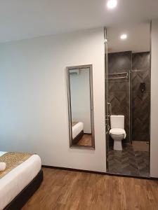 a bathroom with a toilet and a shower with a mirror at Kino Hotel in Shah Alam