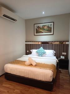 1 dormitorio con 1 cama con 2 toallas en Kino Hotel, en Shah Alam