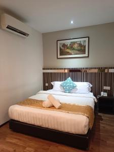 a bedroom with a bed with two towels on it at Kino Hotel in Shah Alam